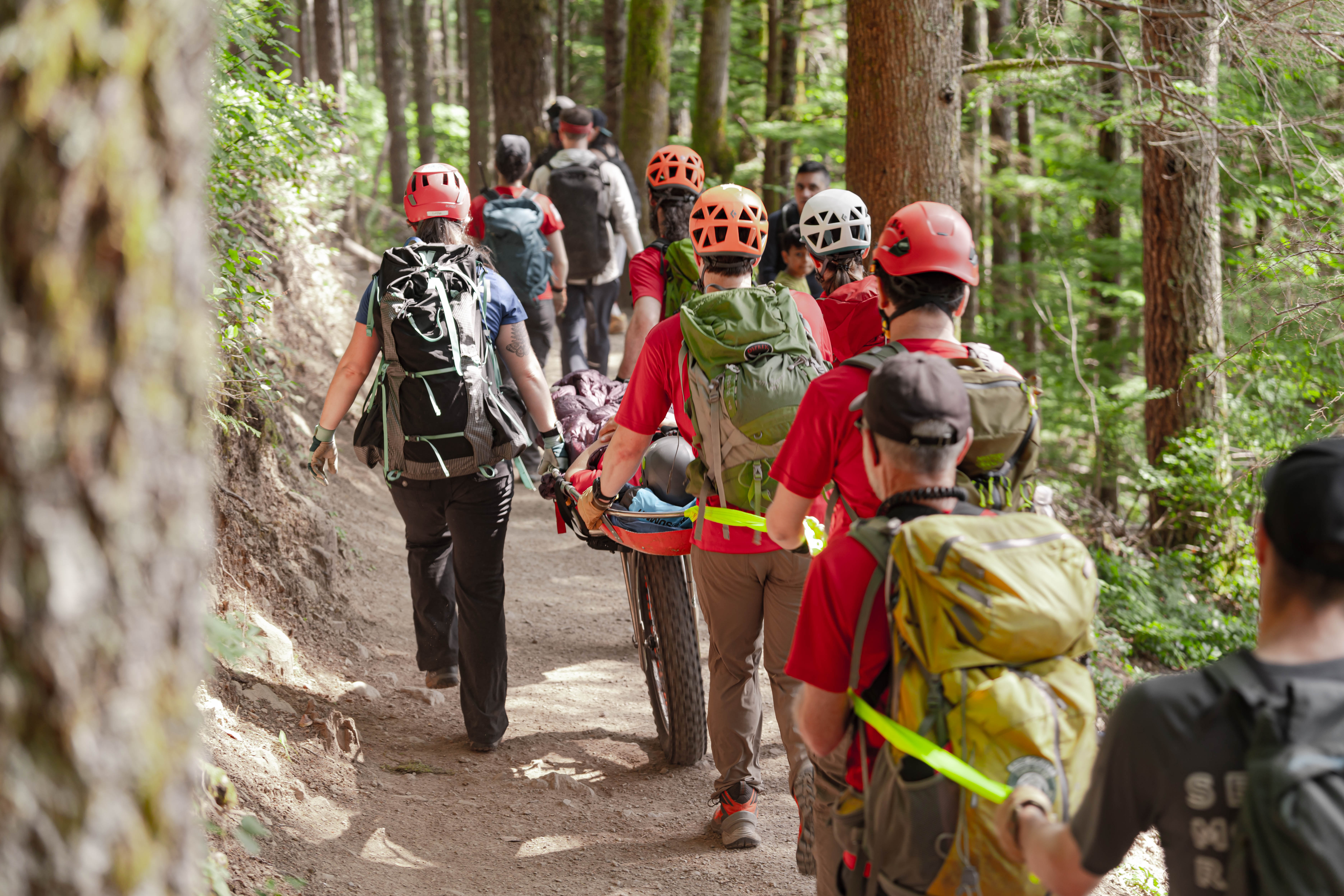 Rescuers using a litter to take subject down a trail