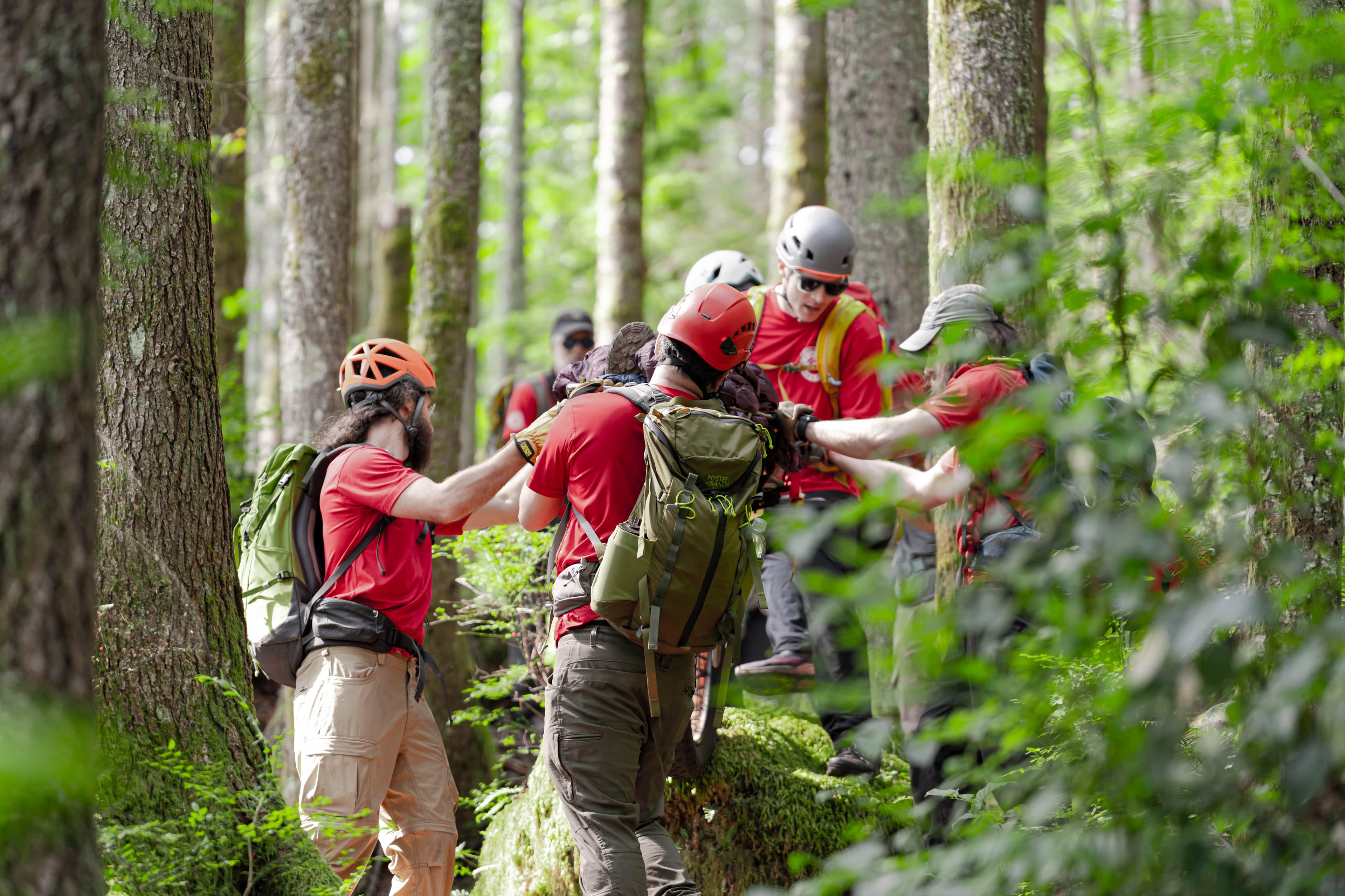 Rescuers navigating a litter over an obstacle